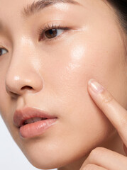 Obraz premium Fresh Asian Beauty Portrait with Woman Gently Touching Her Radiant Cheek