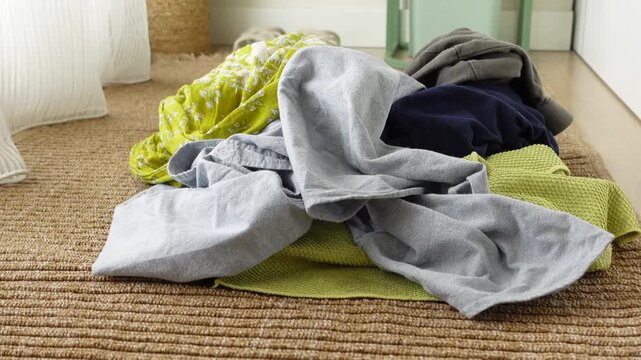 A colorful array of clothes is strewn across a floor mat in a well-lit room