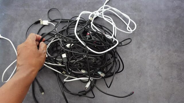 A chaotic and disorganized bunch of tangled cables rests on the table