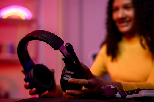 African American girl wearing headphones while playing online video game. 
