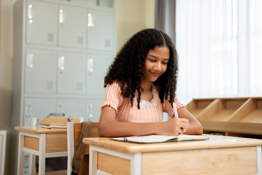 African American schoolgirl learning in classroom at elementary school. 