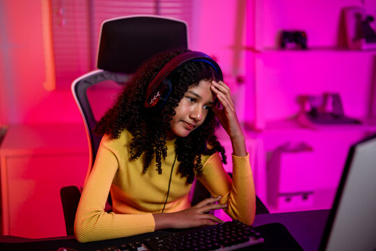 African American teenage girl playing online video game on her computer. 