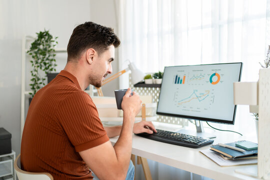 Latino man freelancer using computer while working in living room at home. 