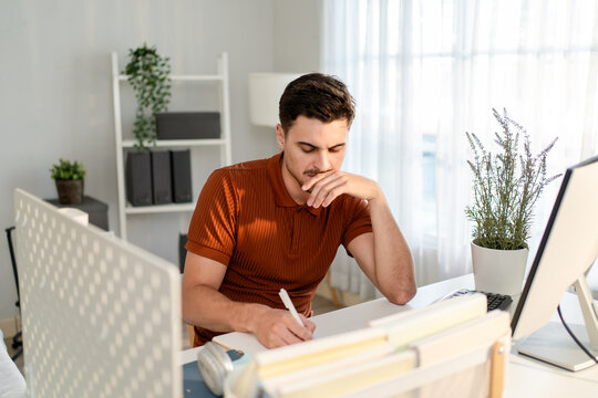 Attractive Latino man freelancer working in cozy living room at home. 