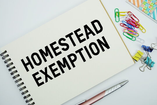 Homestead Exemption text message written on notepad with stationery flat lay on white background