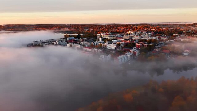 Aerial drone panoramic &ouml;andscape view of lakeside city during autumn morning in middle of fog and mist. 
