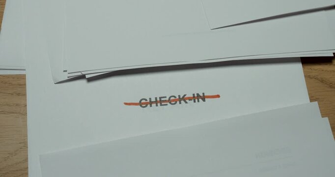 Close-up of the word Check-In being crossed out with a red pen. Concept for cancelled check-in, travel changes, rejected registration, cancellation and changed plans.