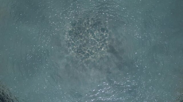 Moving water surface with light reflections and natural texture from above