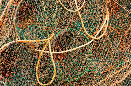 Italy, Sardinia, Bosa. Brightly coloured fishing nets piled up on the dock in the harbour
