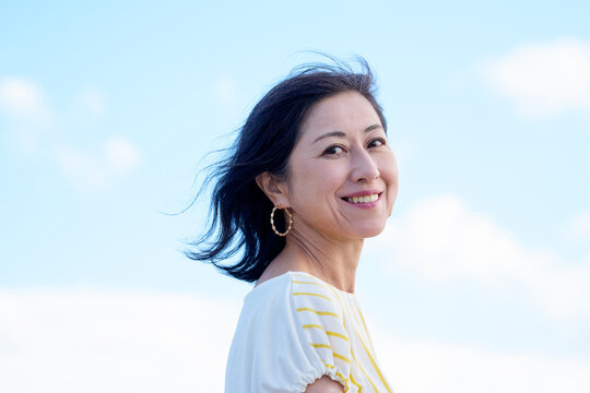 爽やかな笑顔で振り向く日本人女性　空バック