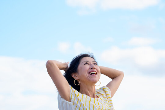 笑顔で深呼吸する日本人女性　空バック