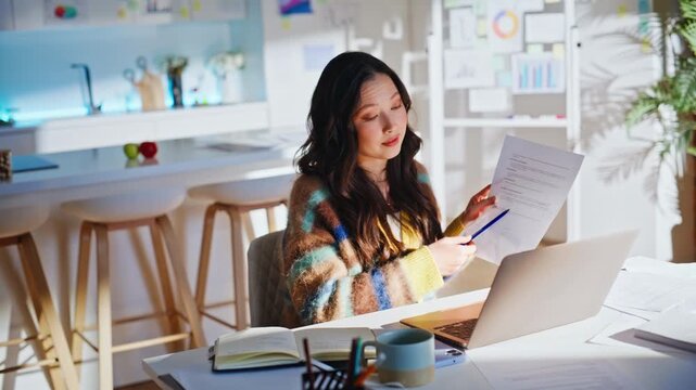 Business woman video call laptop home office. Reading document, taking notes.