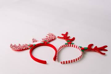 Red christmas reindeer headbands with glittery antlers isolated on white background, ideal for holiday party, costume accessory, and celebration.  © Ryan