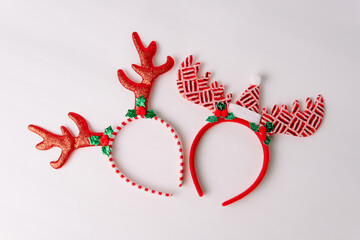 Two festive reindeer headband accessories with glitter antlers on white background, ideal for holiday party, christmas costume, and winter celebration.  © Ryan