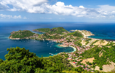 Fototapeta premium Panoramic aerial view over the bay, village, and green hills of Terre-de-Haut island in Les Saintes, Guadeloupe.