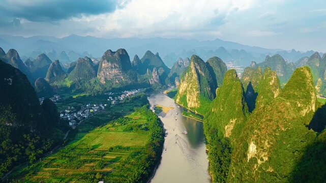High angle view reveals dramatic karst mountain peaks, winding river, and lush green fields during daylight near Xianggong Mountain.