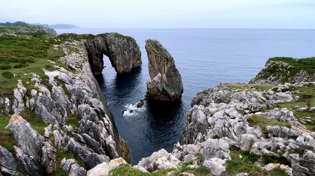 natural rock arch and stone pillar on scenic ocean coast landscape- Asturias coast in Spain