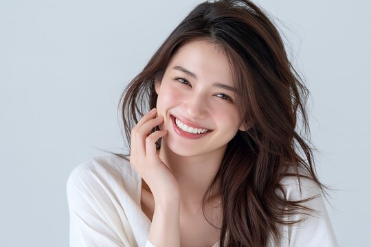 輝く笑顔が素敵な若い女性の肌と髪が美しいポートレート