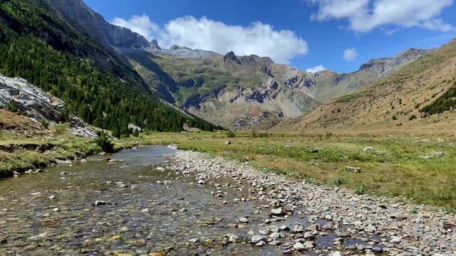 scenic mountain valley with clear river stream flowing through nature landscape under blue sky, Pyrenees