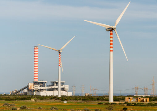 Italy, Sardinia, Porto Torres.  The Fiume Santo coal burning power station, alongside newer wind turbines