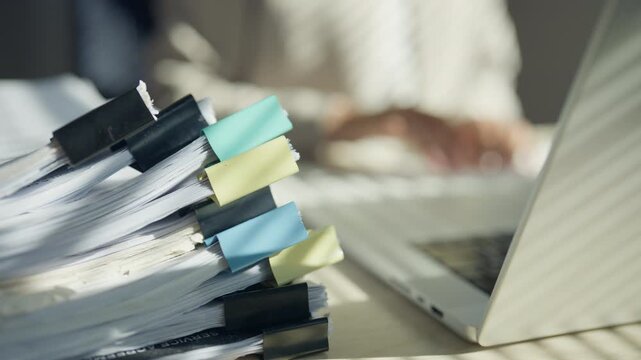 Legal worker examining documents from stacked case files, representing evidence review, investigation, legal research, litigation strategy, case preparation, documentation, and judicial procedures.