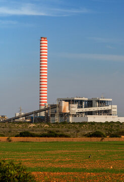 Italy, Sardinia, Porto Torres.  The Fiume Santo coal burning power station with it's tall red and white striped smokestack.