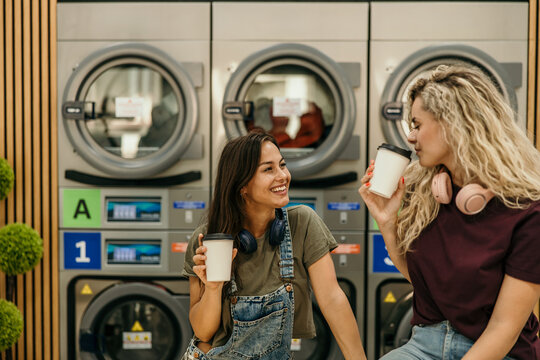 Young women enjoying coffee during laundry day