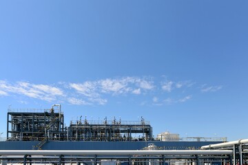 Fototapeta premium 晴れ渡る青空の下で力強く稼働する日本の工業プラント設備