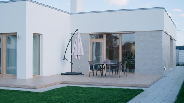 Modern single-story house with a flat roof and white facade.