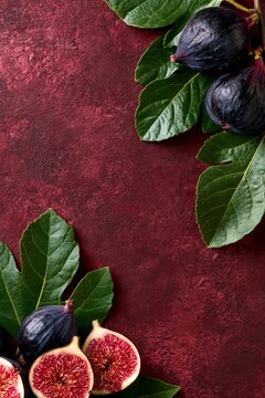 Fresh figs rest on rich, textured red background
