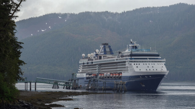 Breathtaking mountain glacier range view with luxury cruiseship cruise ship liner Summit sailing in front of Alaska mountains departure from Hoonah, Icy Strait Point with spectacular landscape scenery