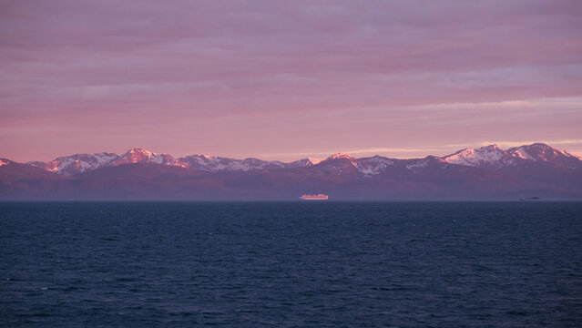 Breathtaking Alaska mountain glacier range view seen with Princess cruise ship cruiseship liner sailing the Inside Passage transit with spectacular landscape scenery during sunset