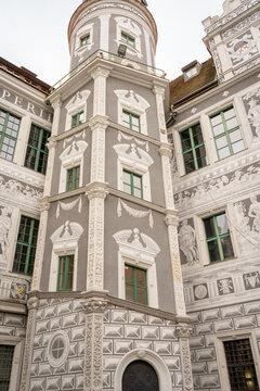 Renaissance tower corner with sgraffito decoration in Dresden, Germany, historic building exterior (Renaissancebau) with green-framed windows and ornamental stonework on gray plaster facade