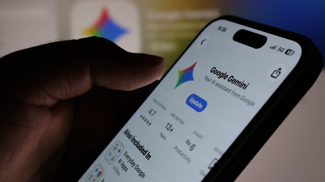 User hand holding smartphone screen showing Google Gemini artificial intelligence app store interface.