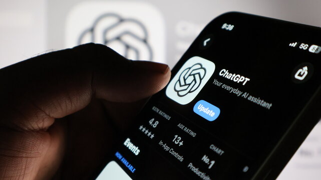 Close up of person using ChatGPT app on mobile phone with 5G signal.