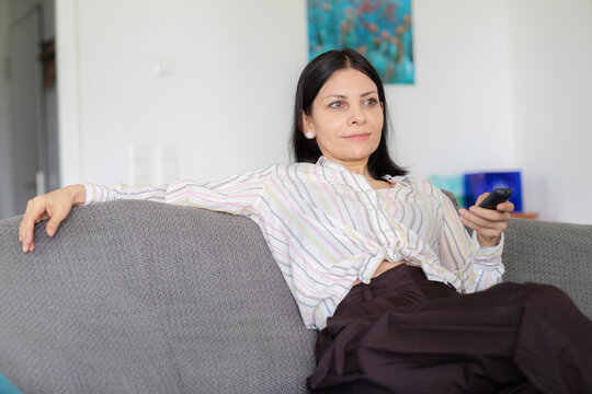 Woman relaxing on the couch watching television at home
