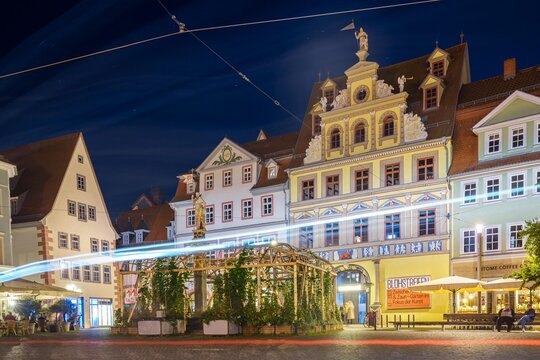 Light trails from a tram streak past historic Renaissance facades of the Kunsthalle Erfurt and the Stute "Der R&ouml;mer" on Erfurt Fischmarkt at night, ideal for travel