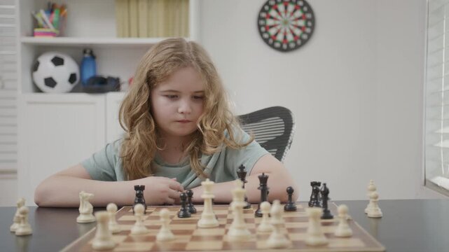 Kid concentration through chess. Child playing classic chess game. Kid learning problem solving with chess. Child developing intelligence with chess.