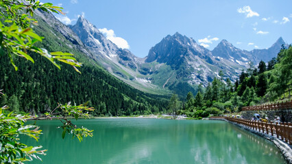 Obraz premium Landscape of the lake and greenery forest with four girls mountain range in Bipenggou, Chengdu China
