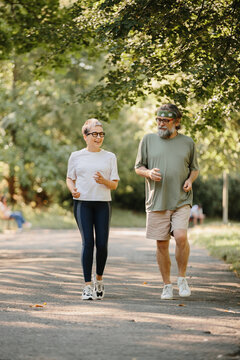 Senior couple jogging in park enjoying healthy lifestyle
