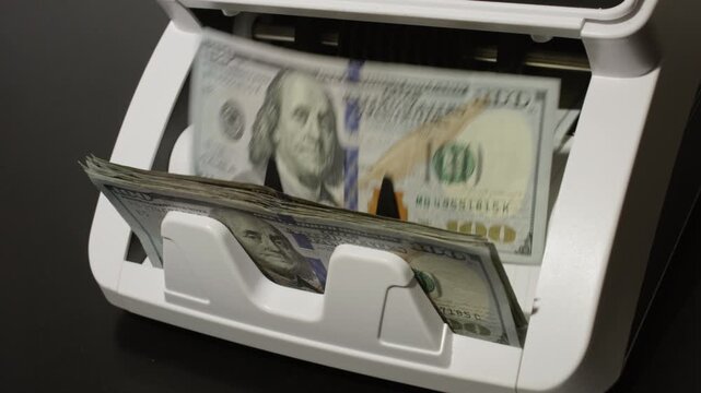 Cash counting machine working with US dollars currency. Money counting process. Business and finance. Cash counting machine in motion. Investment and banking concept with Counting money.