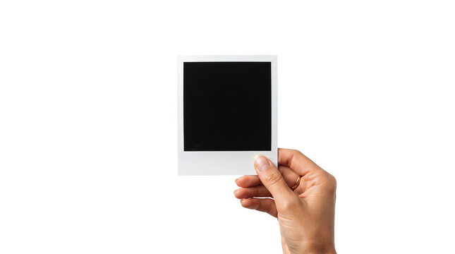 Blank instant photo frame held by hand. Person holding white photographic paper with dark space for custom picture. Isolated studio photo for mockup, memory, and nostalgia presentation.