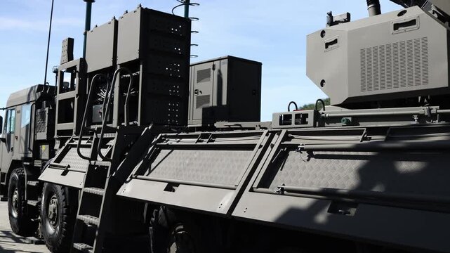Military tactical vehicle carries armored equipment modules electronic systems antennas and heavy field hardware designed for mobile defense and command operations onsite