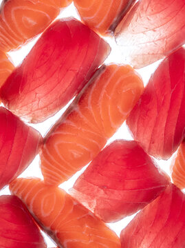 Sliced raw salmon and tuna sashimi arranged edge to edge, close-up texture