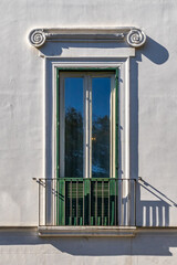 Obraz premium Classic European Architecture Detail Showcasing Green Shutters and Wrought Iron Railing