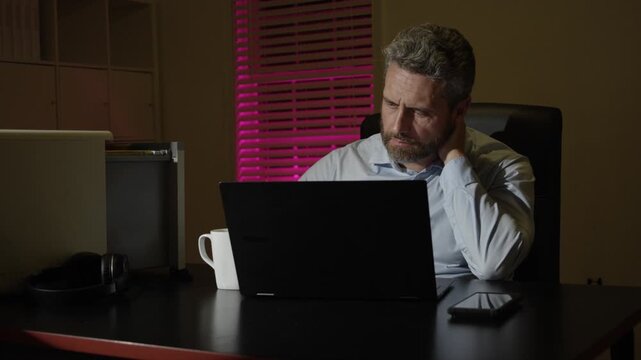 Business man thinking in night office. Busy freelancer. Night deadline. Office worker dealing with fatigue and anxiety. Businessman overworked and exhausted at night. Employee working late.
