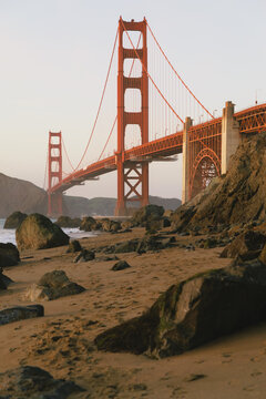 Golden Gate Bridge seen from a rocky beach at dusk
