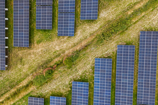 Aerial top down view of solar panels in a green field