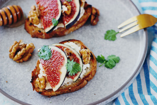 Gourmet fig and walnut toast with cream cheese on a plate