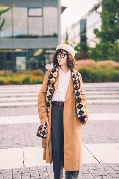 Chic young woman in a beret and trench coat outdoors